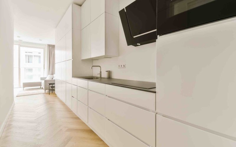 freepik_standard_106019234_11zon Moderne witte keuken met houten vloer