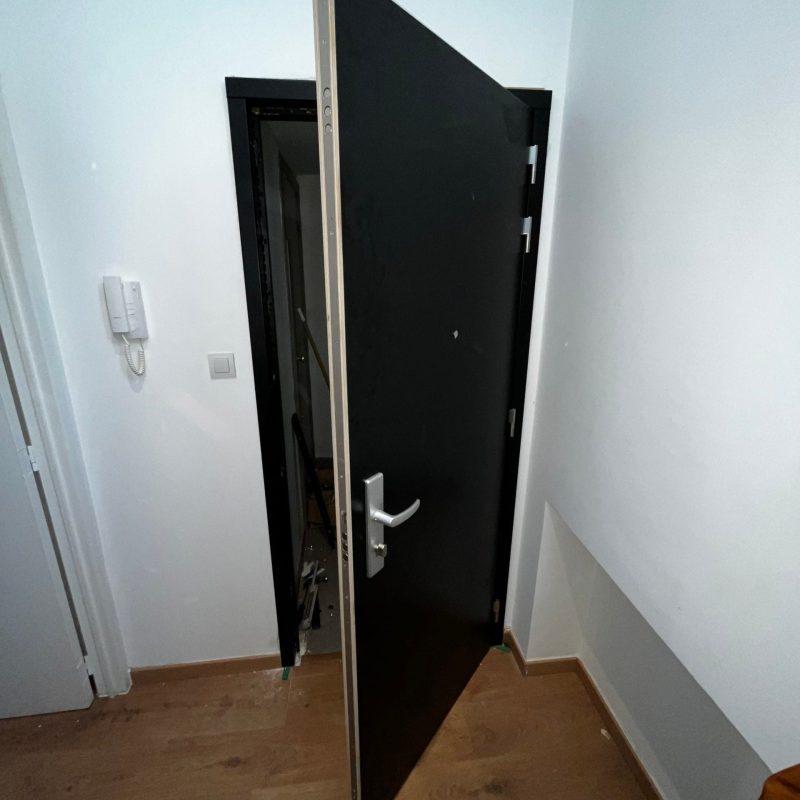 inbraakwerende deuren Zwarte deur geopend naar trap naar beneden.