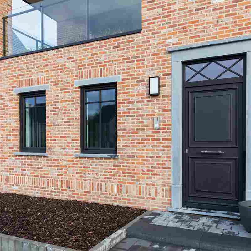 pvc-ramen-in-houtlook_11zon Rode bakstenen muur met zwarte voordeur en ramen